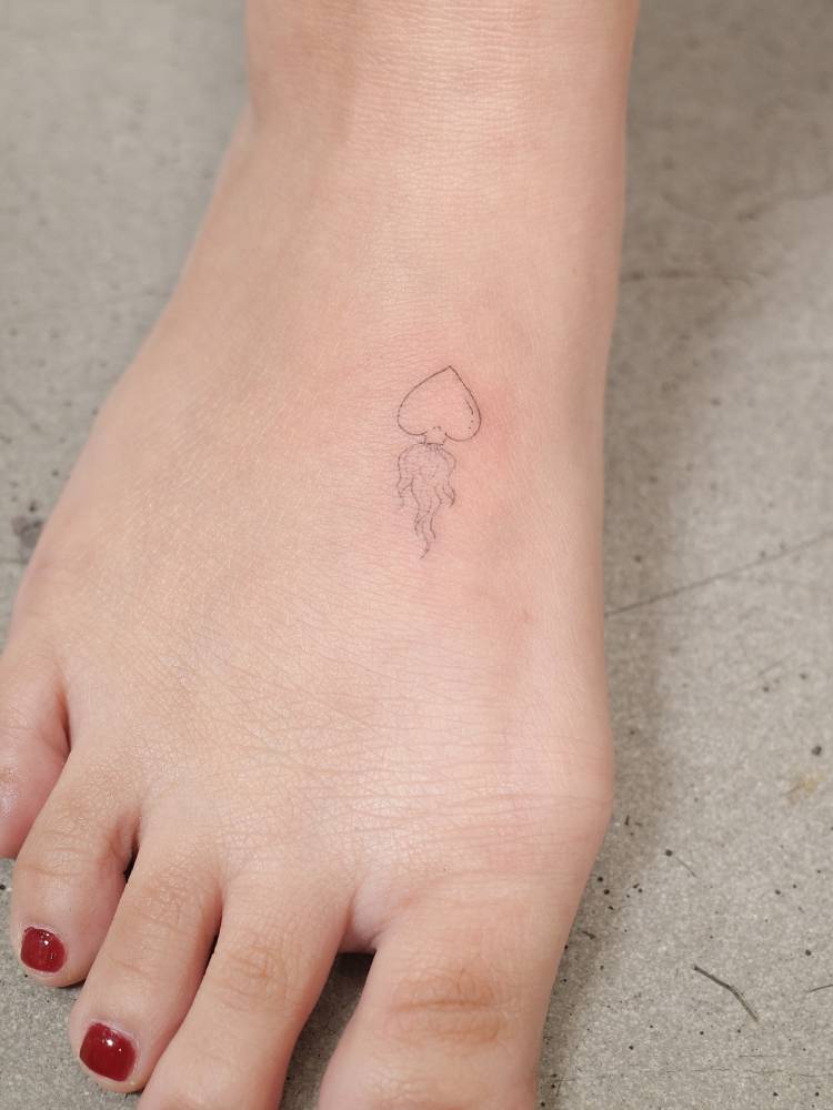Sacred heart tattoo located on the foot, fine line style.