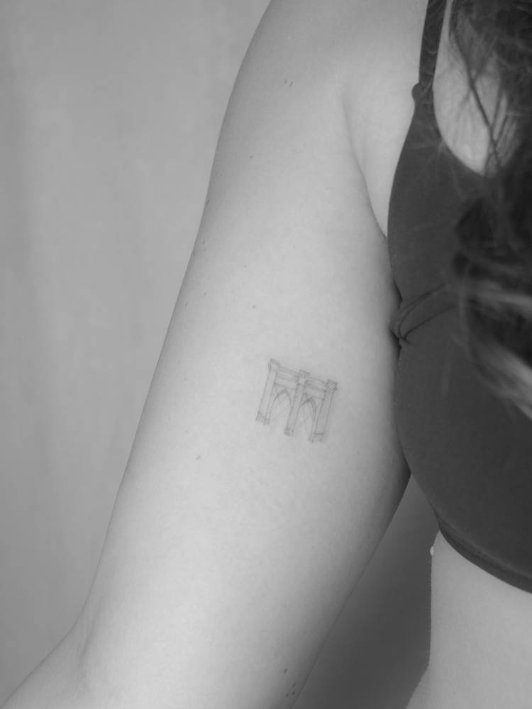 Brooklyn Bridge tattoo in fine line style located on the inner arm.