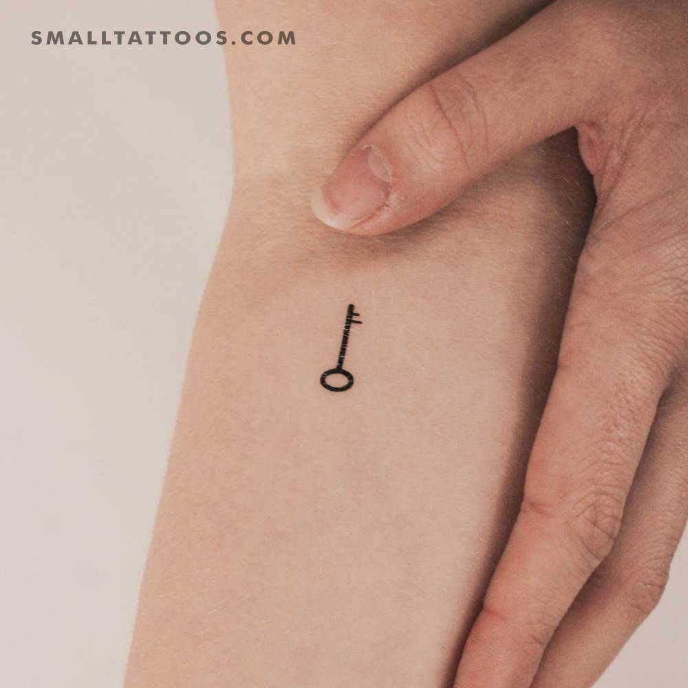 Minimalist key temporary tattoo located on the inner forearm.