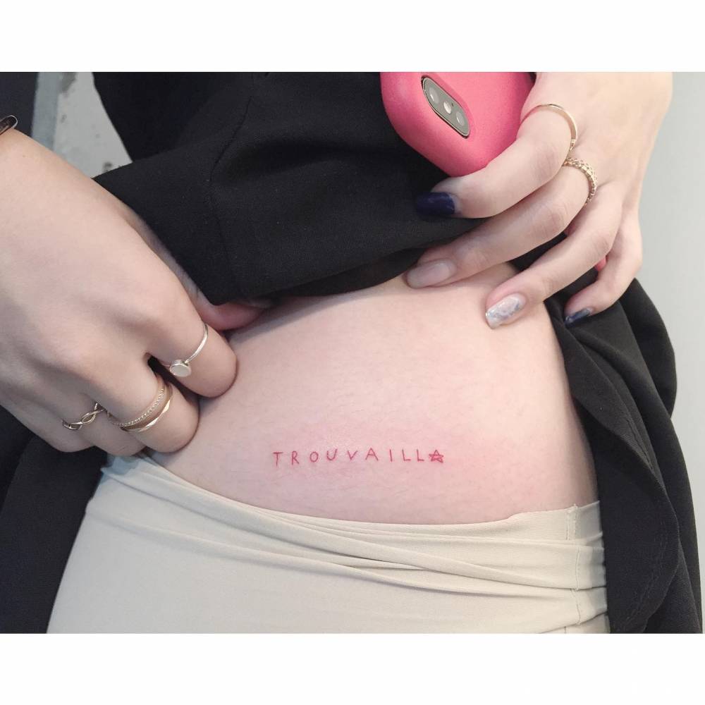 "Trouvaille" lettering tattoo located on the hip.