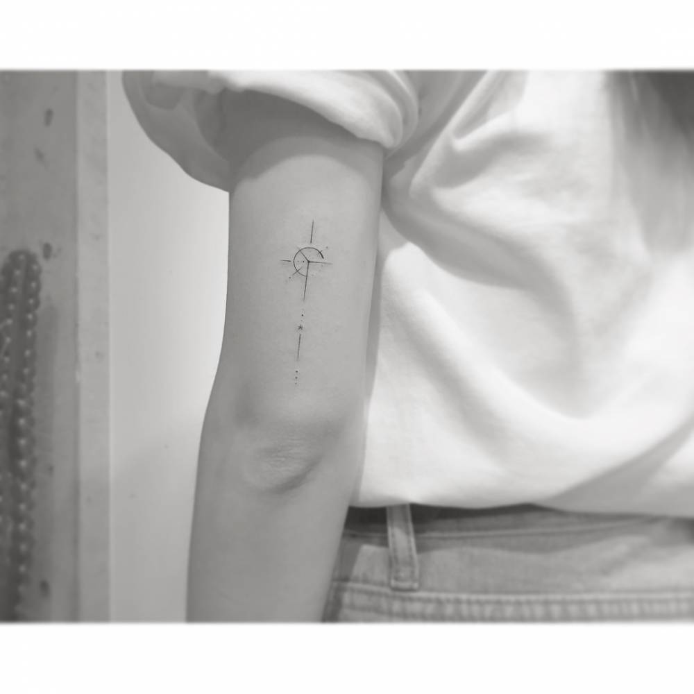 Compass rose in minimalistic style tattooed on the tricep.