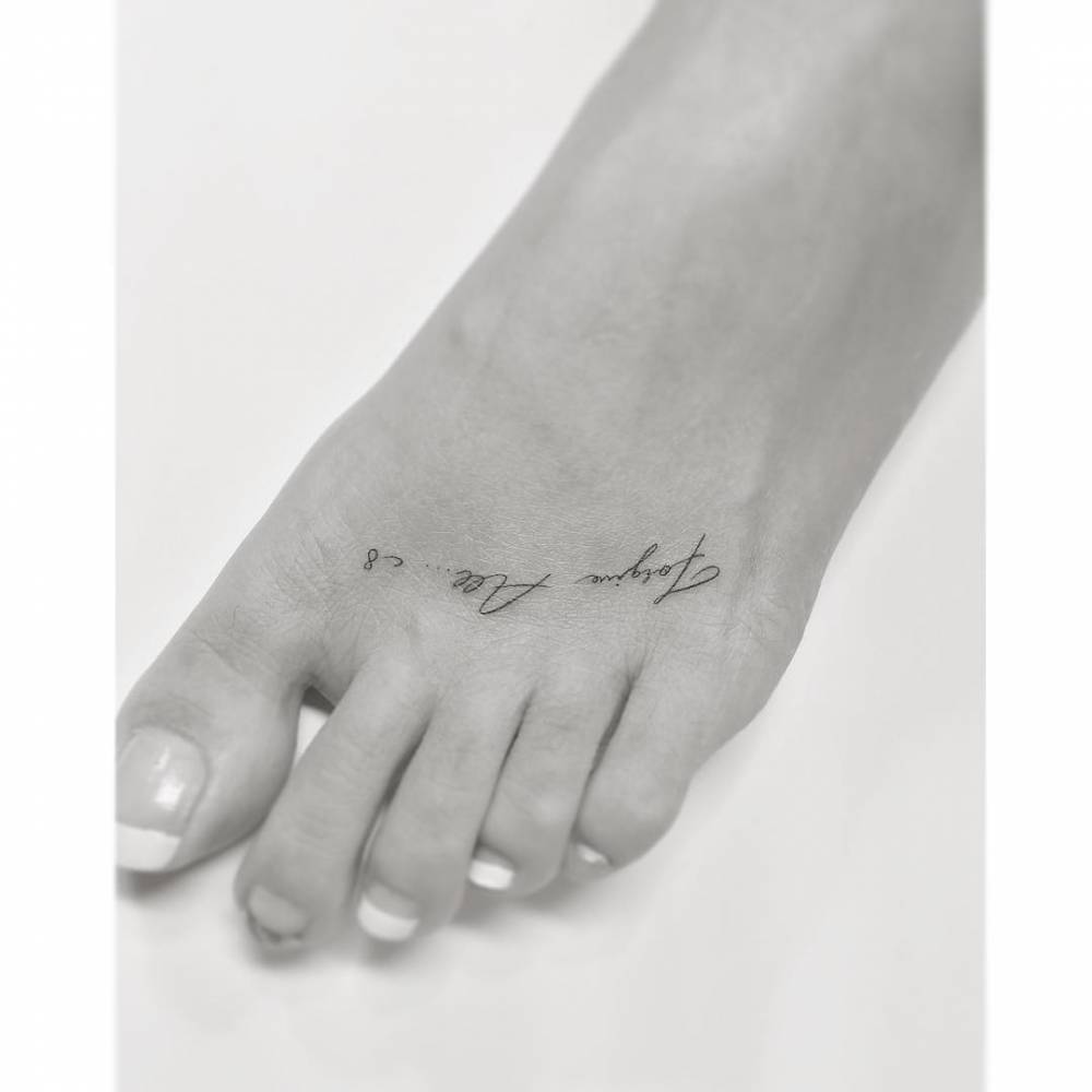 "Forgive all" lettering tattoo in handwritten font done on the foot.