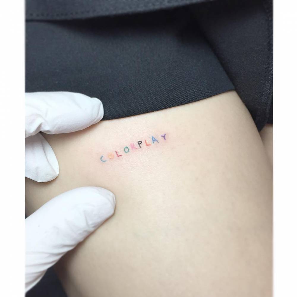 "Colorplay" lettering tattoo in colorful letters.