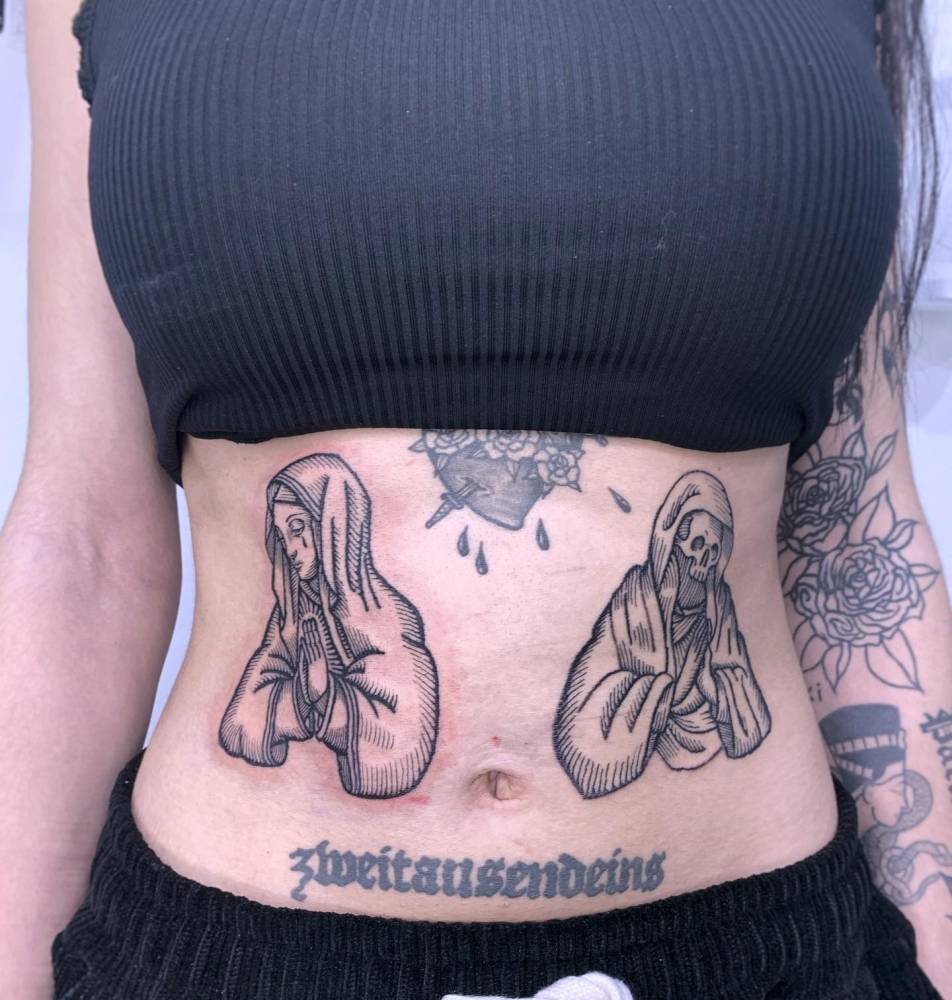 Virgin Mary and Skeleton tattoos located on the waist.