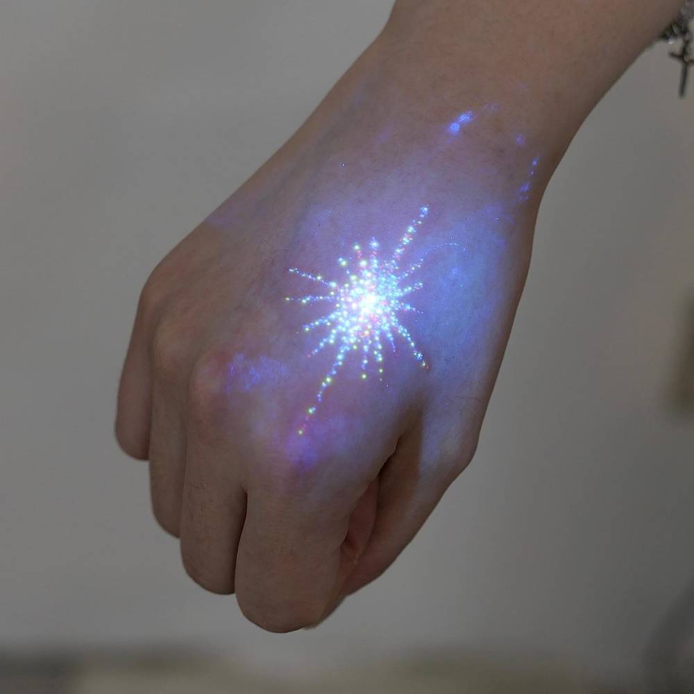 UV ink north star tattoo located on the hand.