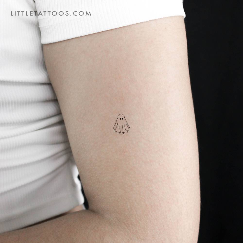 Small fine line ghost temporary tattoo placed on the upper arm.