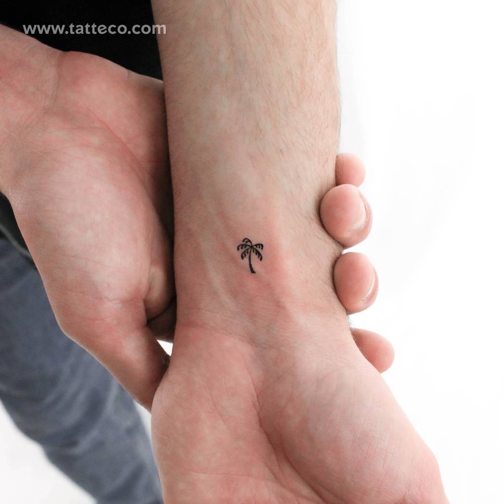 Tiny minimalistic palm tree temporary tattoo located on the wrist.