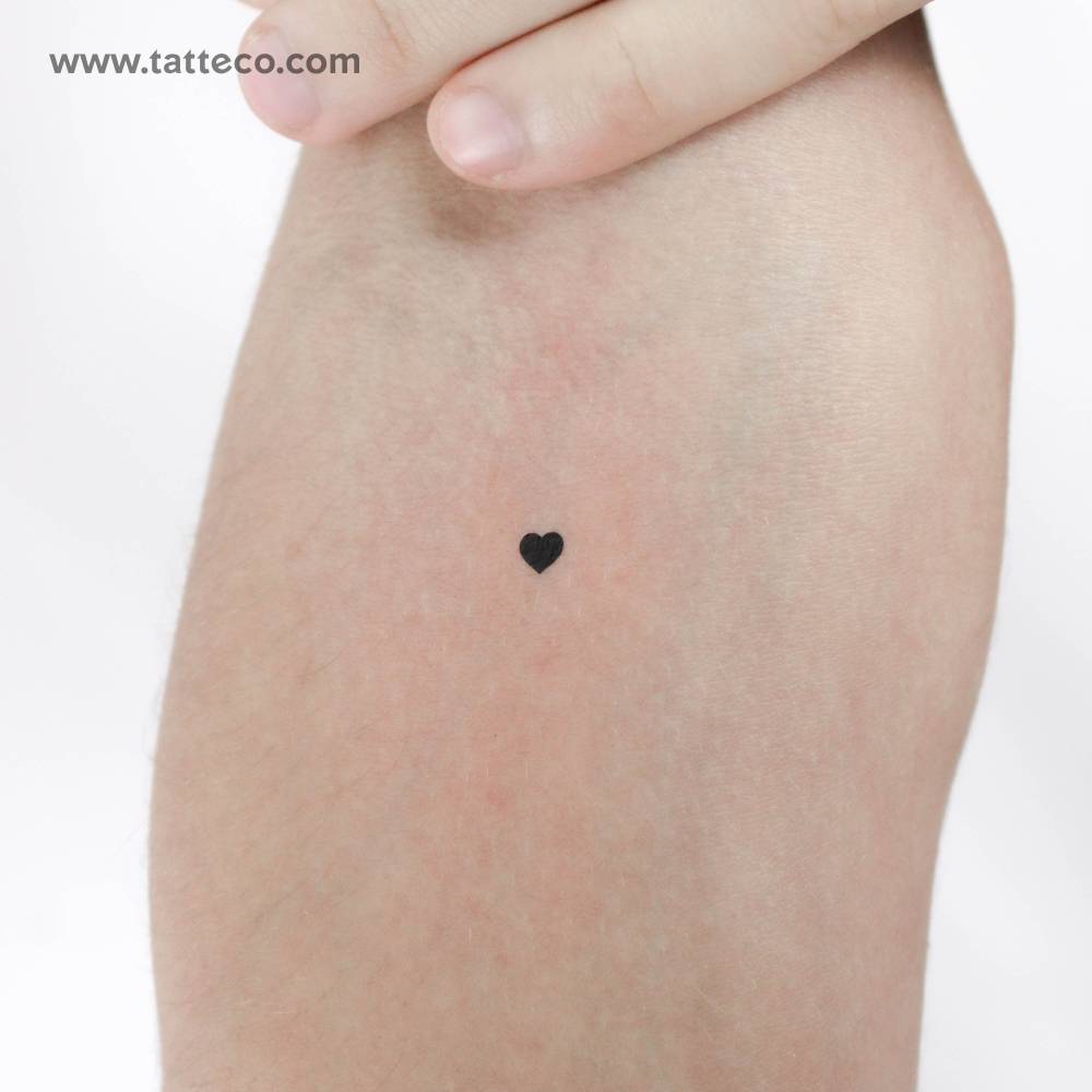 Tiny minimalistic black heart temporary tattoo located on the inner forearm.