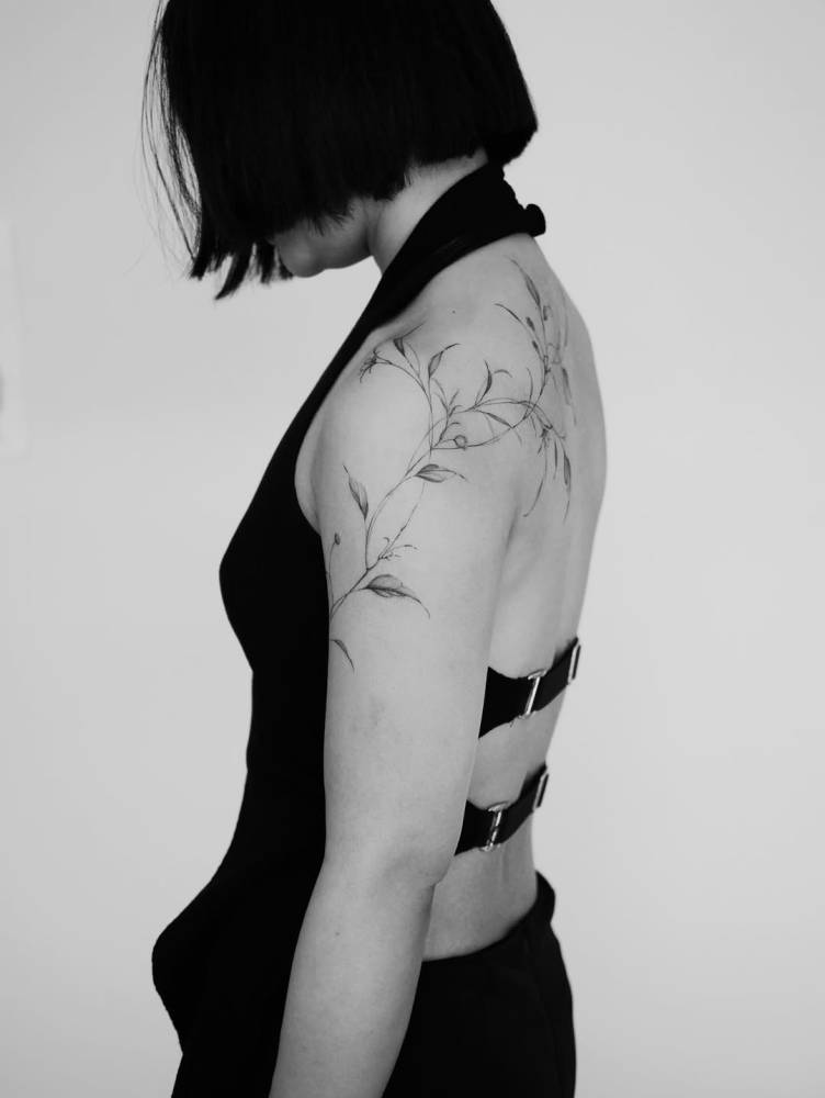 Leaves tattoo in illustrative style located on the shoulder.