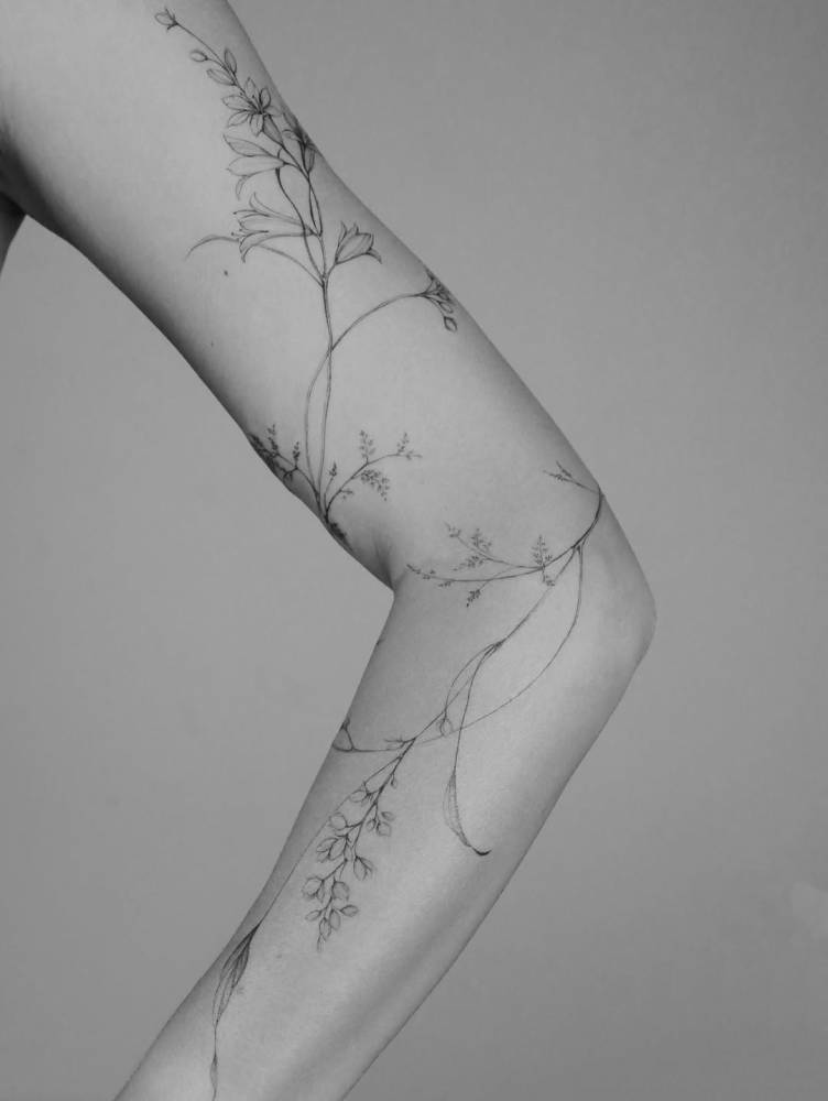 Floral design tattooed on the arm, illustrative style.