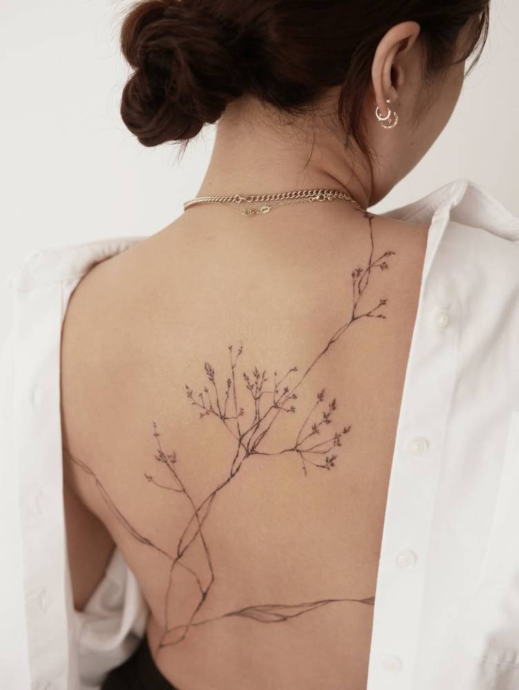 Wildflowers back tattoo in illustrative style.