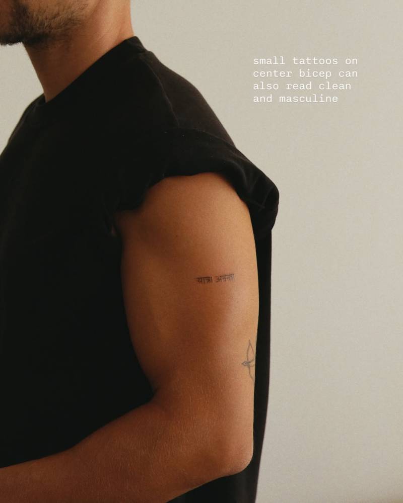 Sanskrit lettering tattoo located on the upper arm.