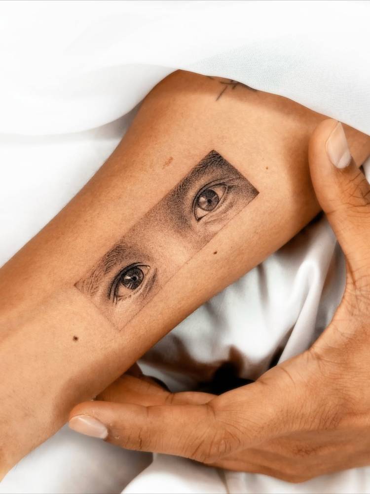 Eyes tattoo in micro-realistic style placed on the inner forearm.