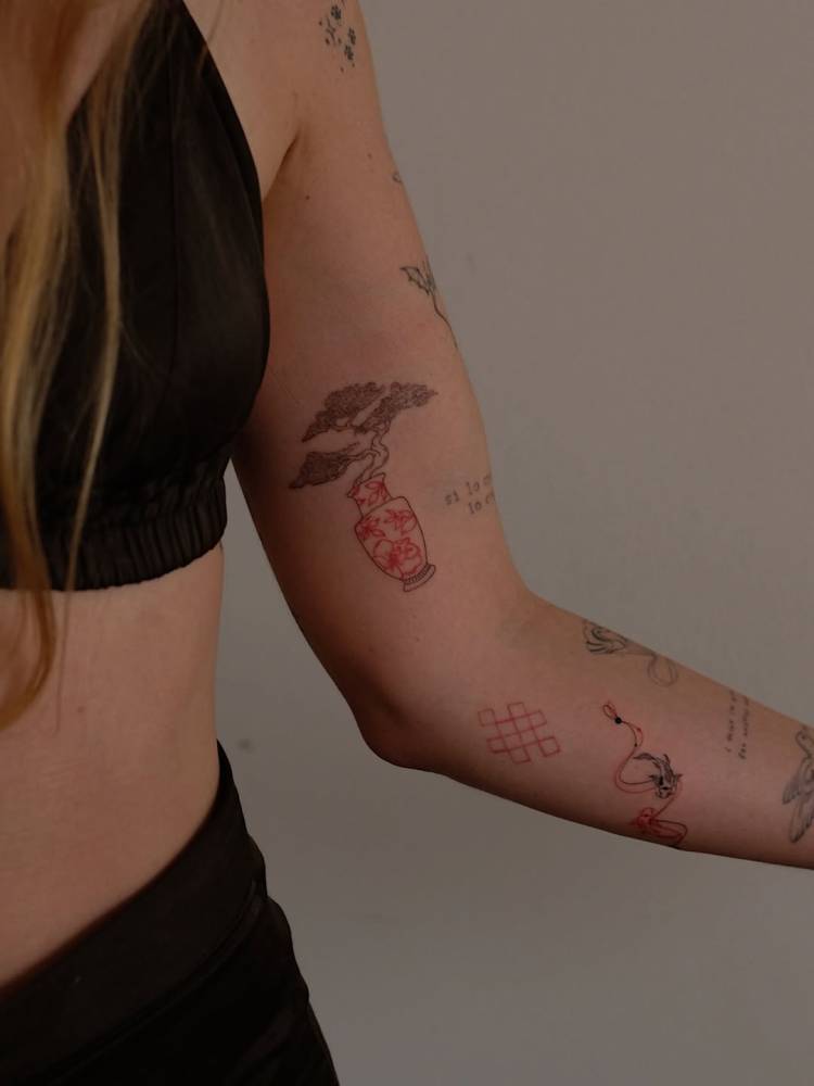 Vase and bonsai tattoo located on the inner arm, fine line style.