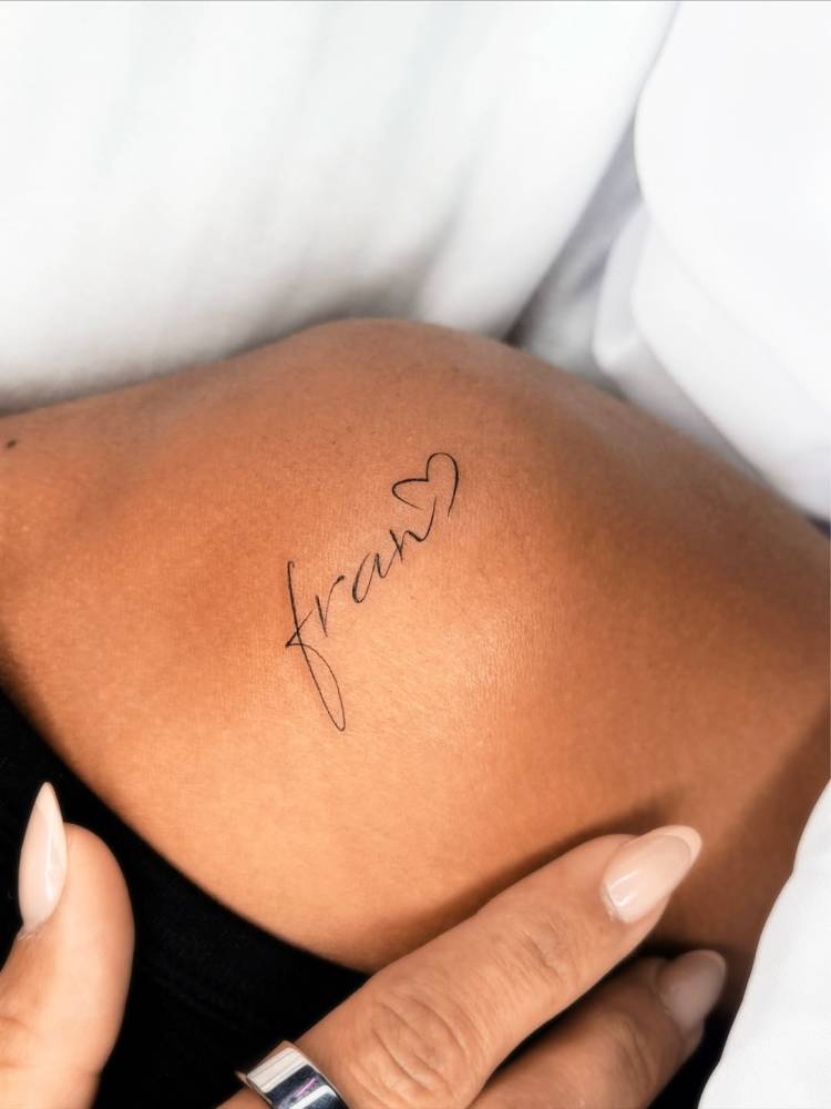 Lettering tattoo of the name "Fran" located on the shoulder.