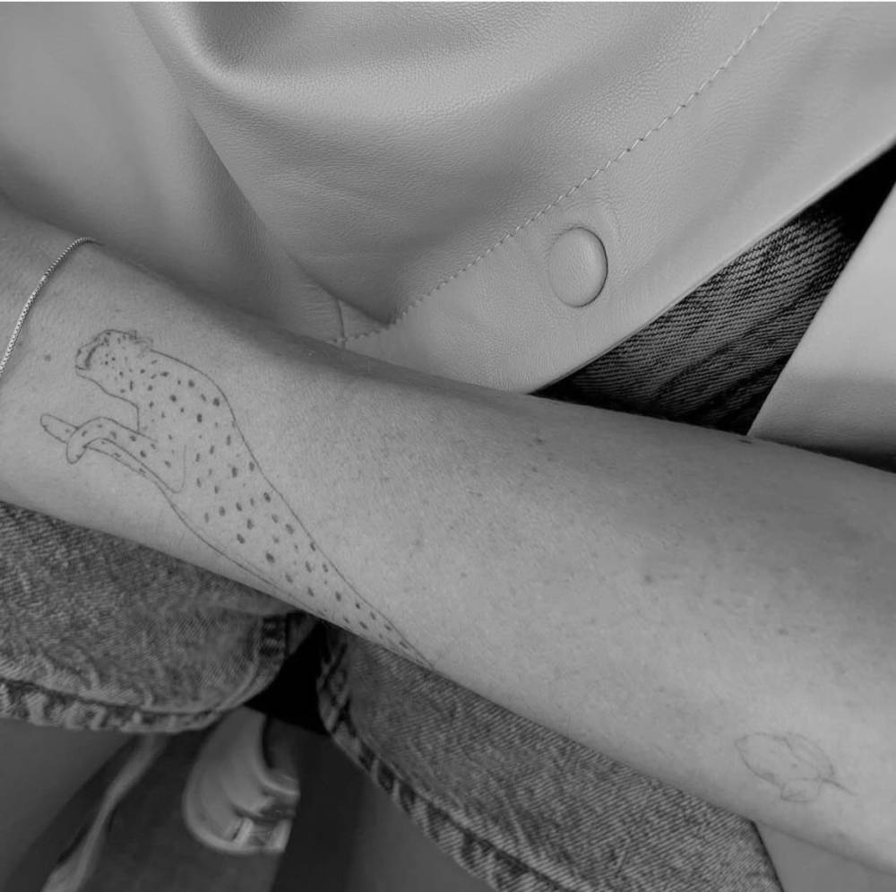 Fine line style leopard tattoo located on the wrist.