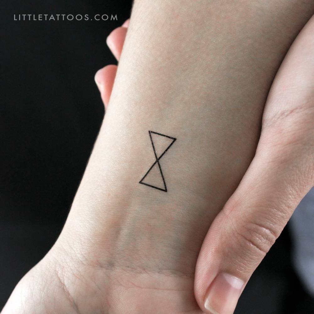 Minimalist hourglass temporary tattoo located on the wrist.