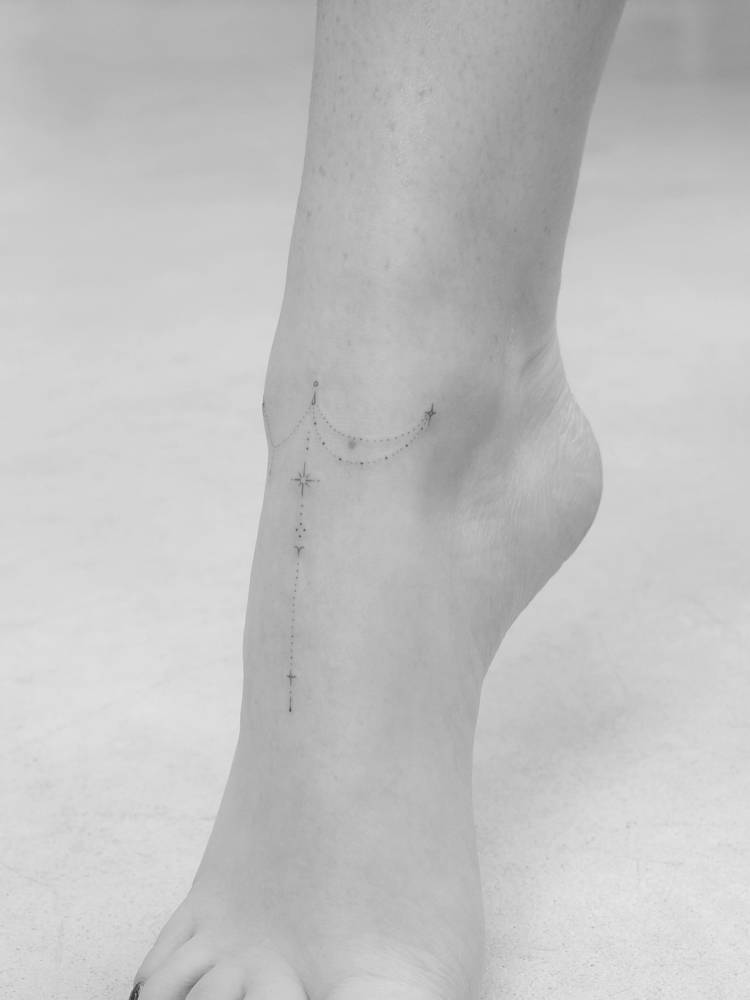 Ornamental design tattooed on the foot, done in fine line style.