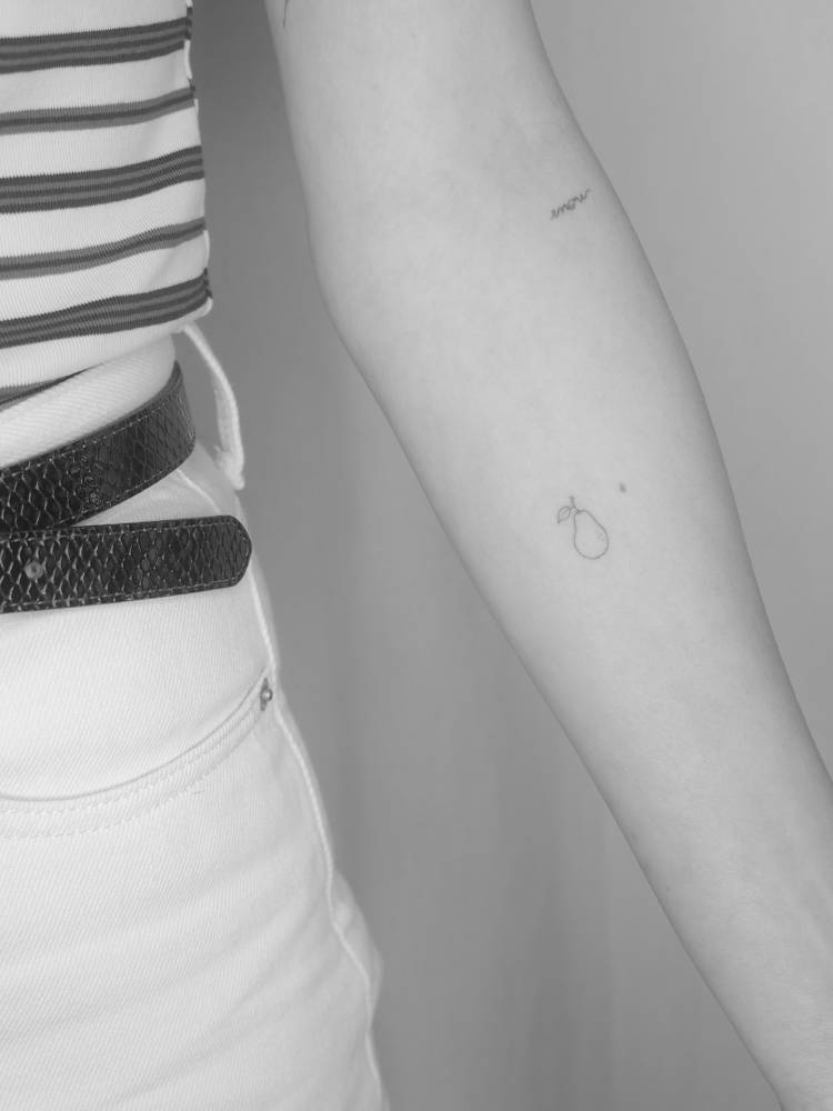 Tiny minimalistic pear tattooed on the inner forearm.