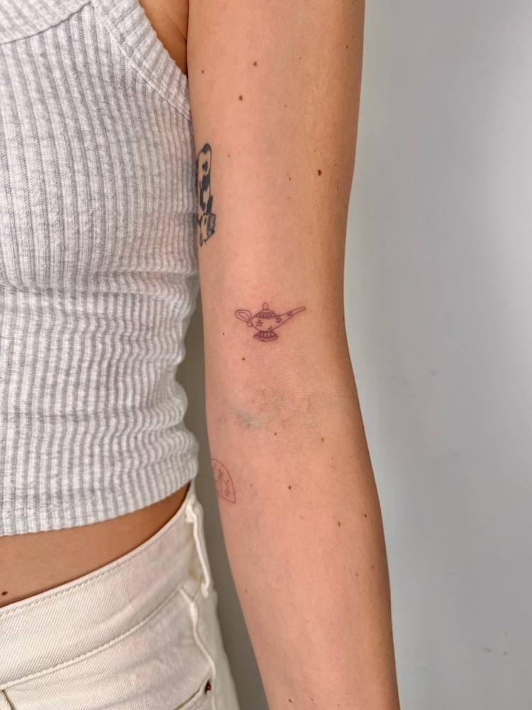 Single needle genie lamp tattoo located on the bicep.