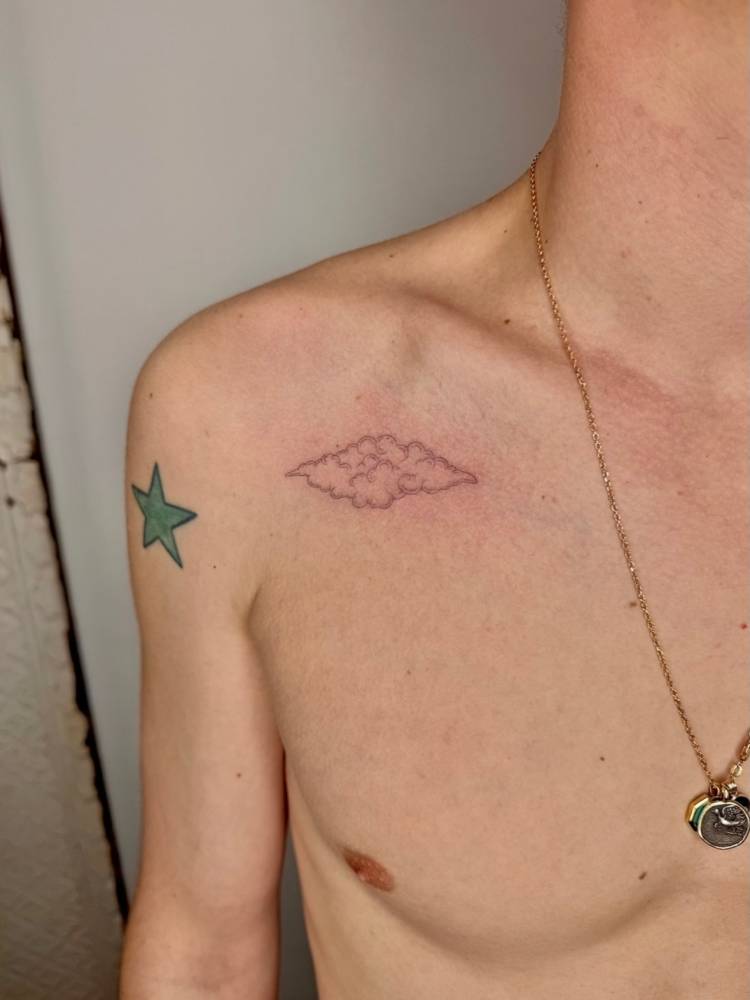 Cloud tattoo located on the collarbone, fine line style.