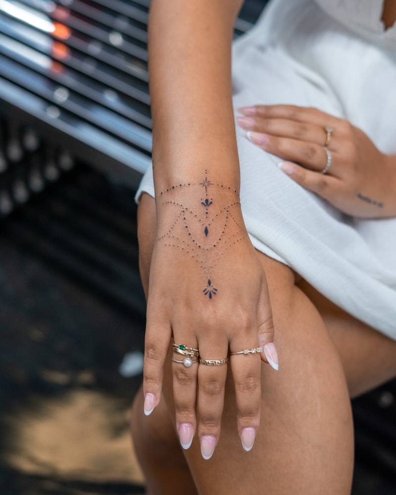 Ornamental design tattooed on the wrist and hand.
