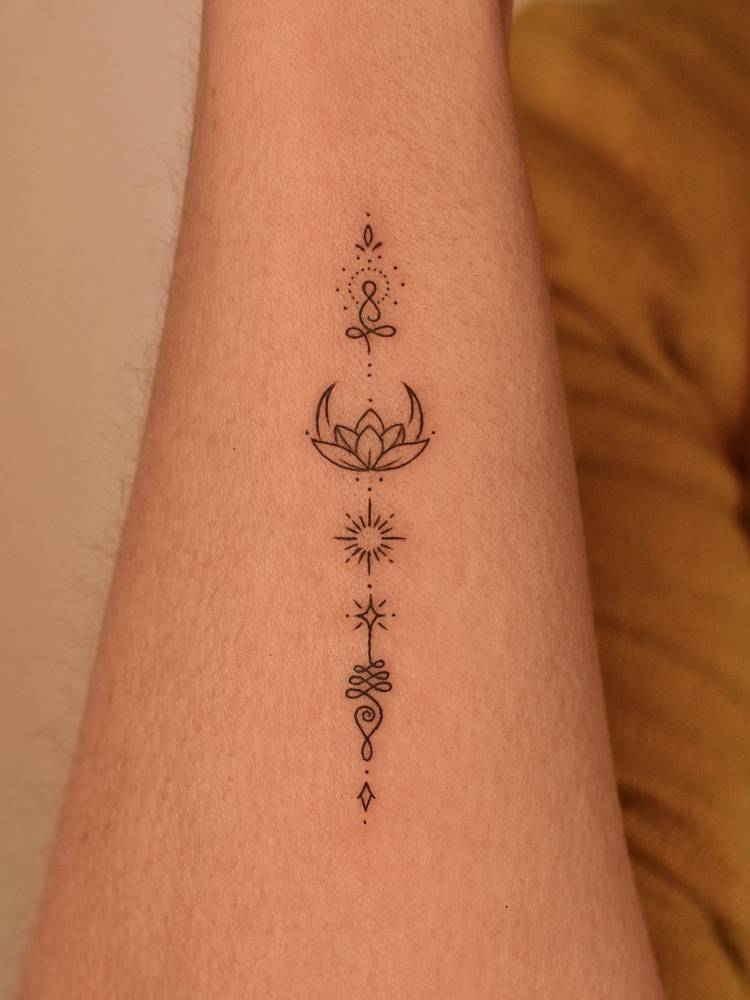 Symbol chain tattoo in fine line style located on the wrist.