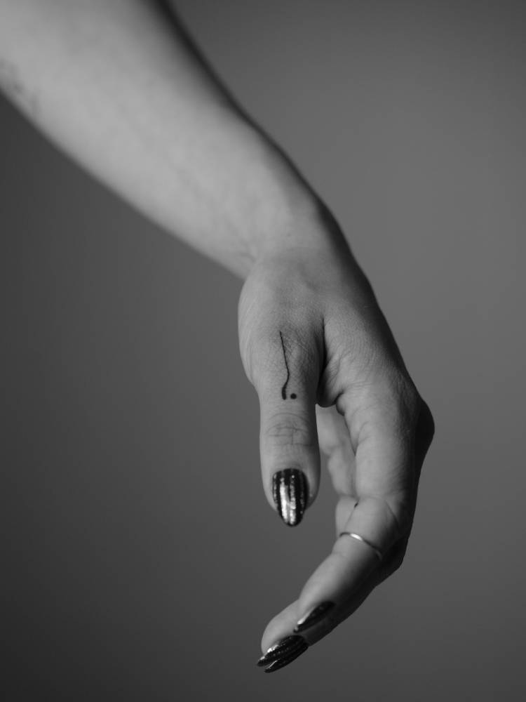 Minimalistic abstract design tattooed on the thumb.