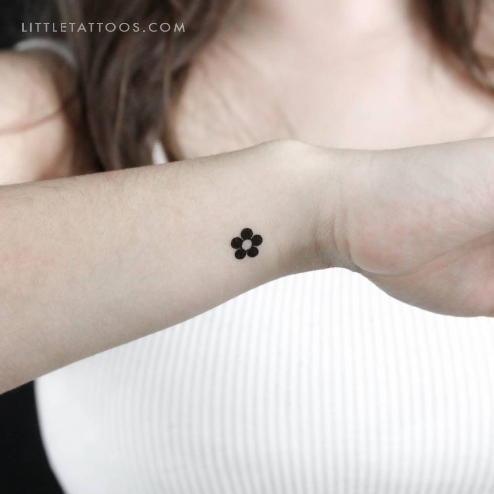 Minimalist flower temporary tattoo located on the wrist.