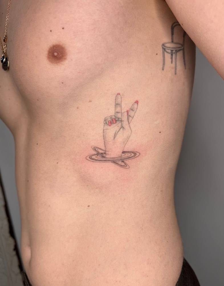 Illustrative style V sign tattoo located on the rib.