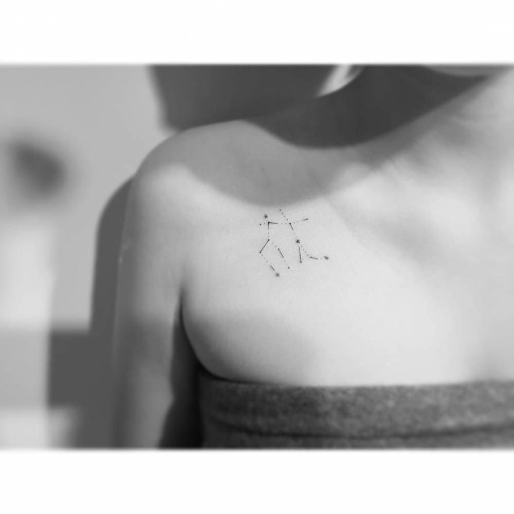 Gemini constellation tattoo placed on the collarbone.