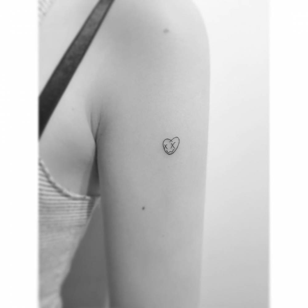 Minimalistic heart tattooed on the upper arm.