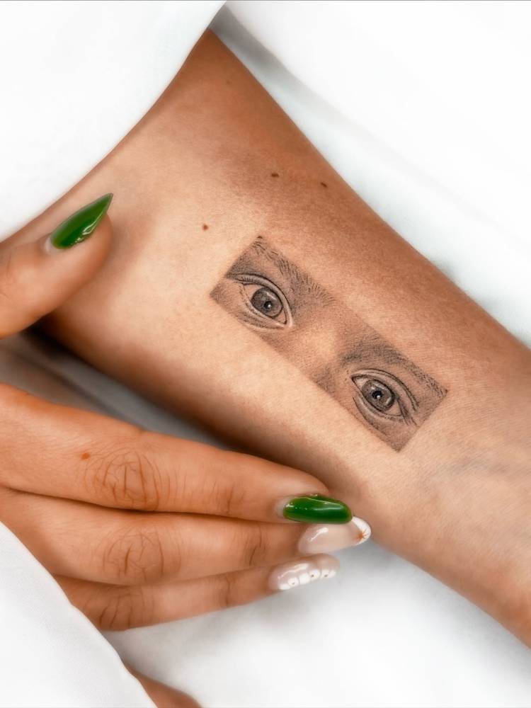 Eyes tattoo in micro-realistic style located on the inner forearm.