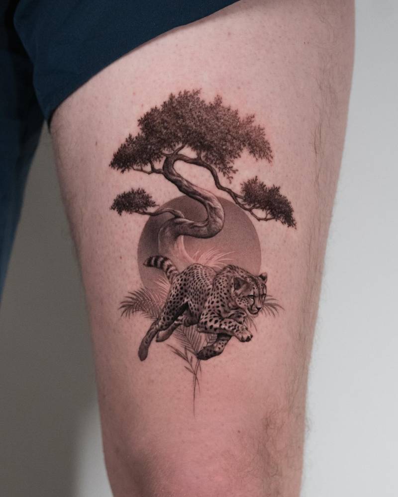 Micro-realistic style cheetah and bonsai tree tattoo located on the thigh.