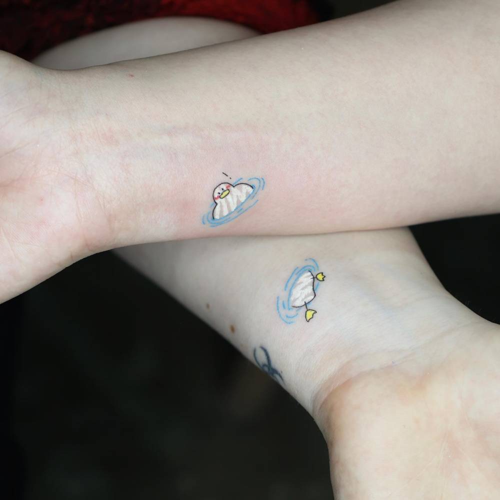 Matching duck tattoo in cartoon style for best friends.
