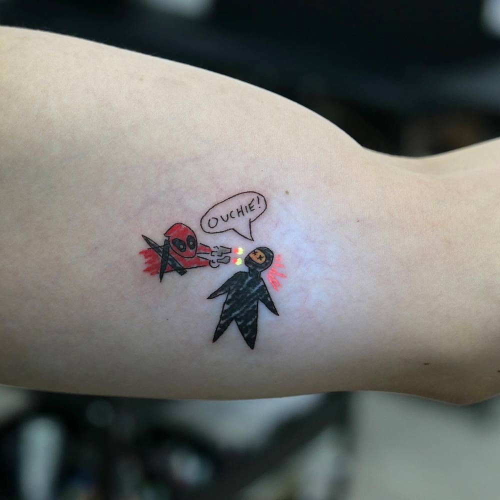 Cartoon style Deadpool tattoo placed on the inner arm.
