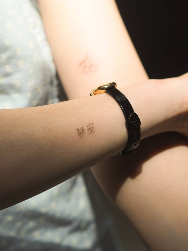 Chinese lettering tattoo located on the wrist.