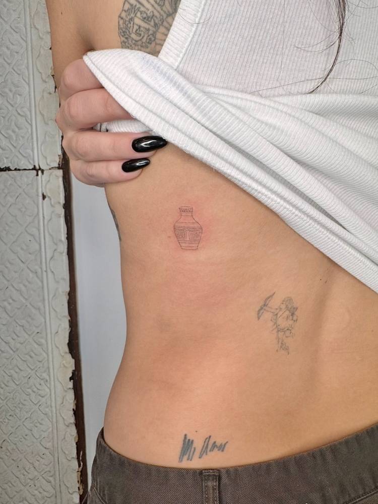 Vase tattoo located on the back, done in fine line style.