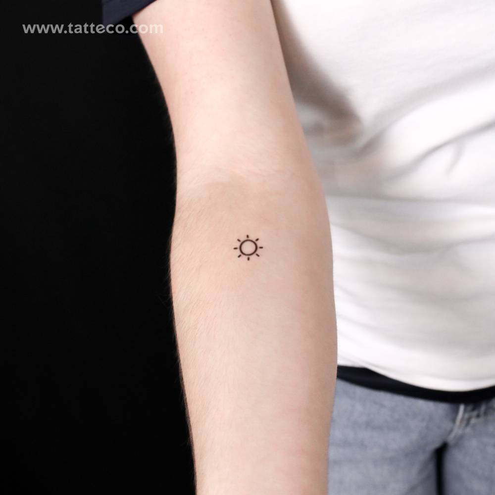 Minimalist sun semi-permanent tattoo located on the inner forearm.
