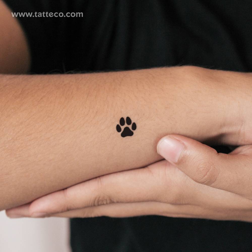 Small dog paw print semi-permanent tattoo located on the wrist.