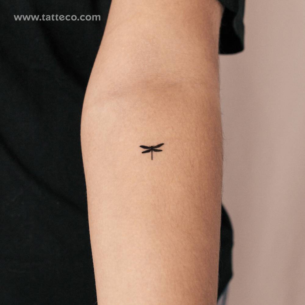 Small minimalist dragonfly semi-permanent tattoo placed on the inner forearm.
