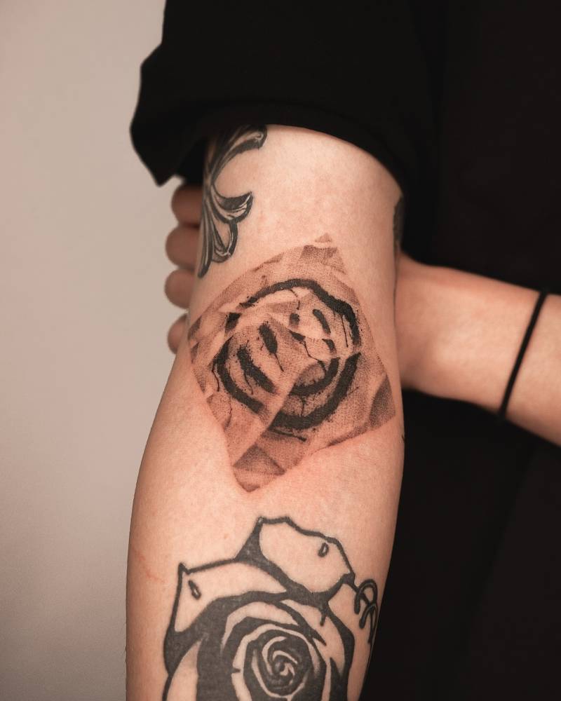 Smiley symbol tattoo located on the bicep, dotwork style.
