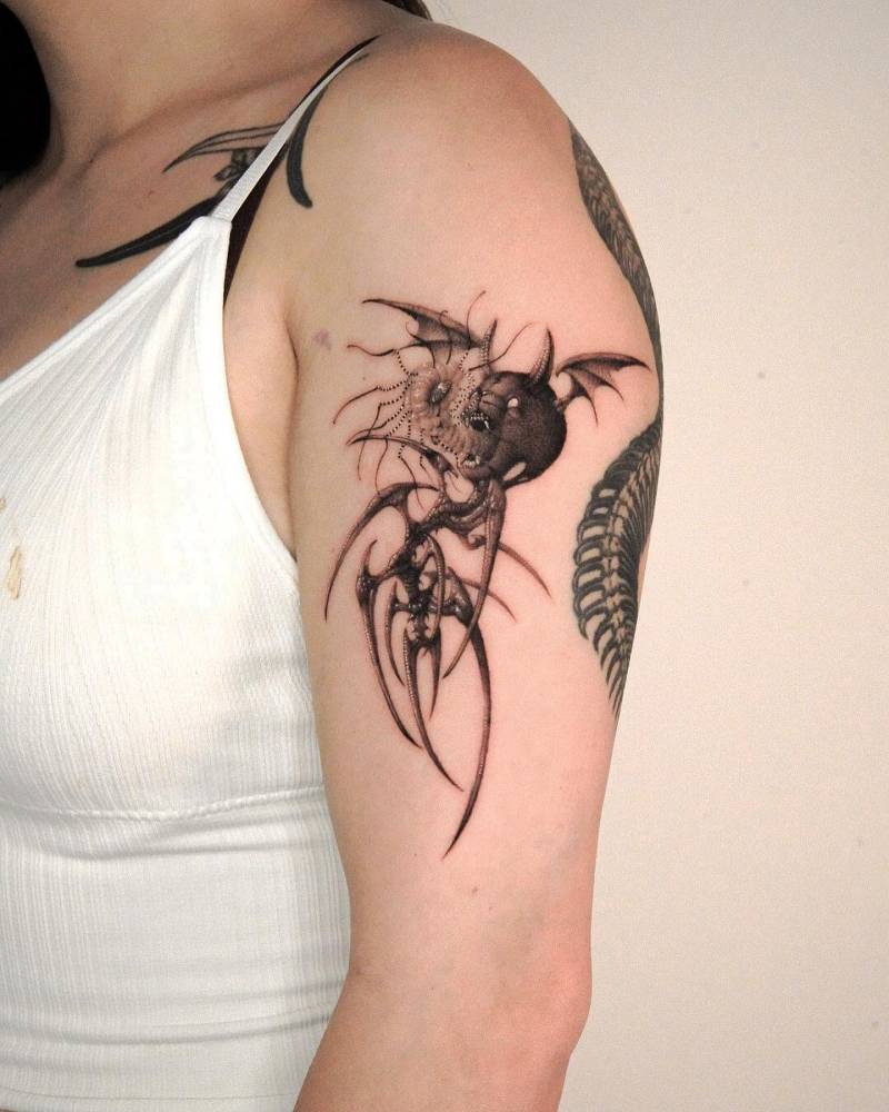 Parasite demon tattoo located on the upper arm.