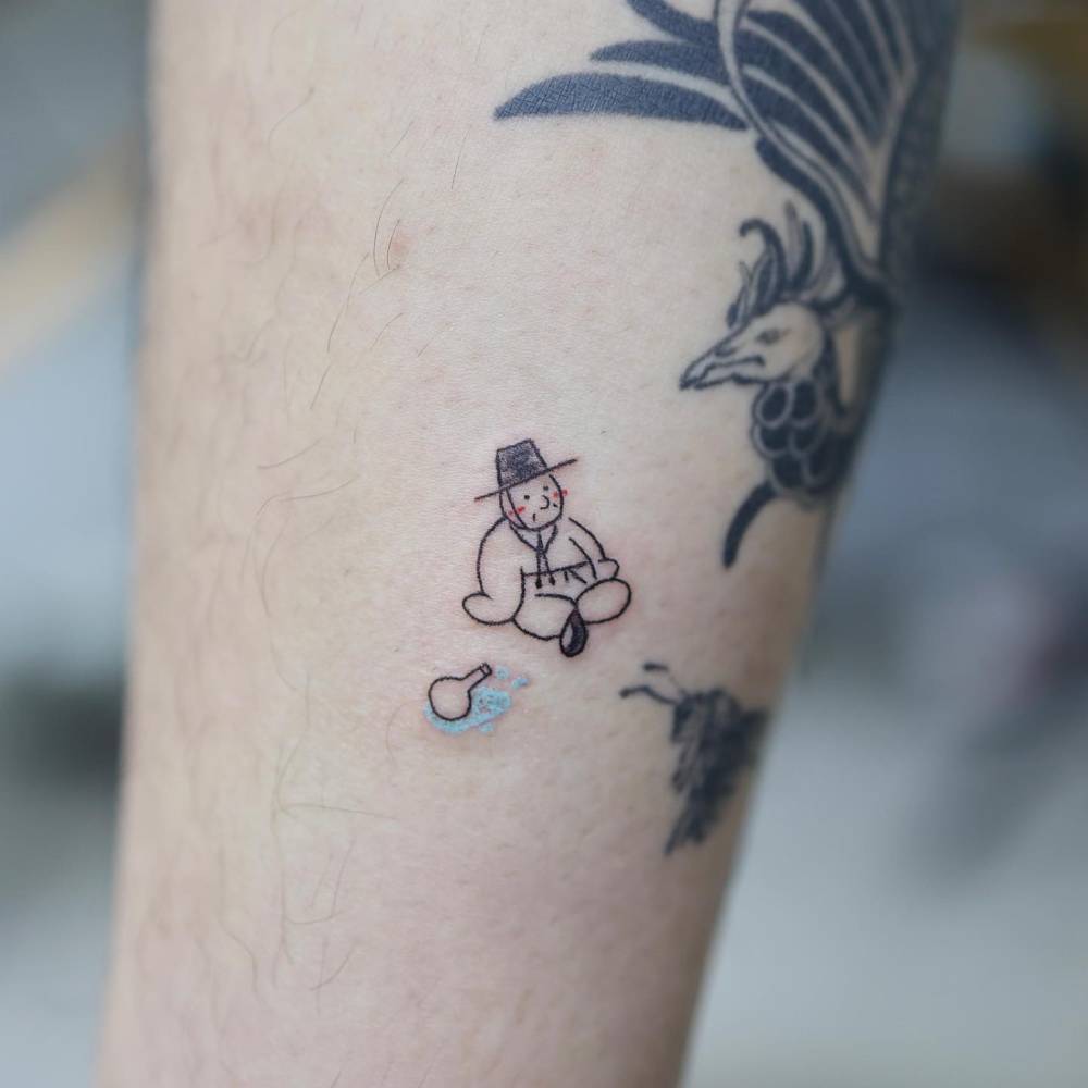 Korean figure tattoo in cartoon style located on the inner forearm.