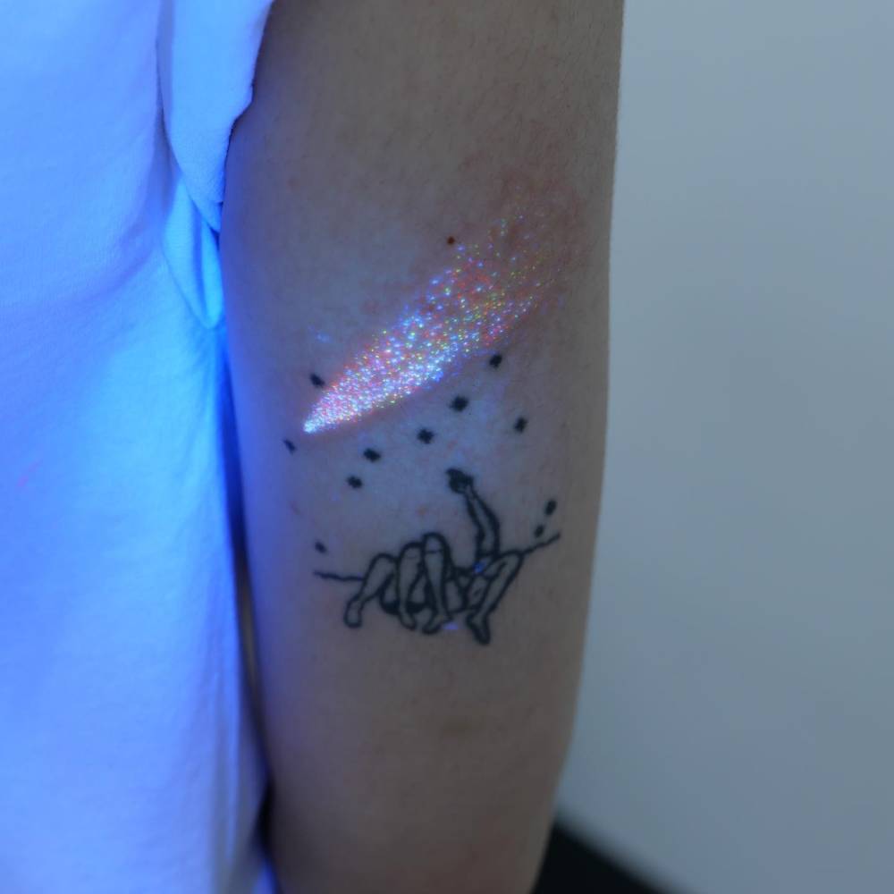 Glitter effect comet tattoo located on the tricep.