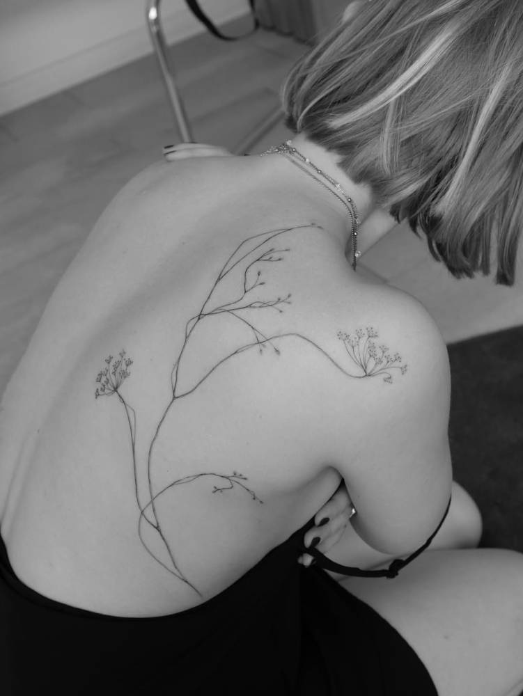 Wildflowers tattooed on back, illustrative style.