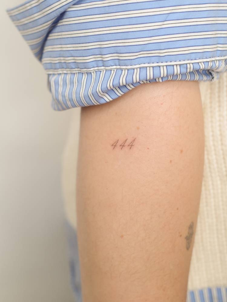 Angel number "444" tattoo located on the forearm.