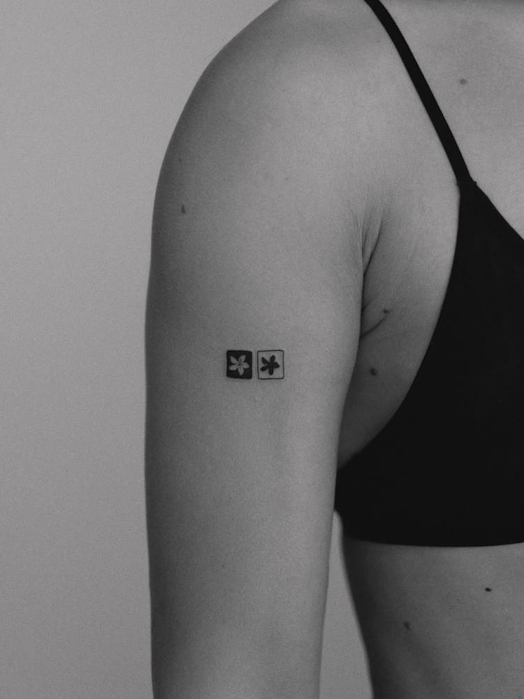 Minimalistic flowers tattooed on the upper arm.