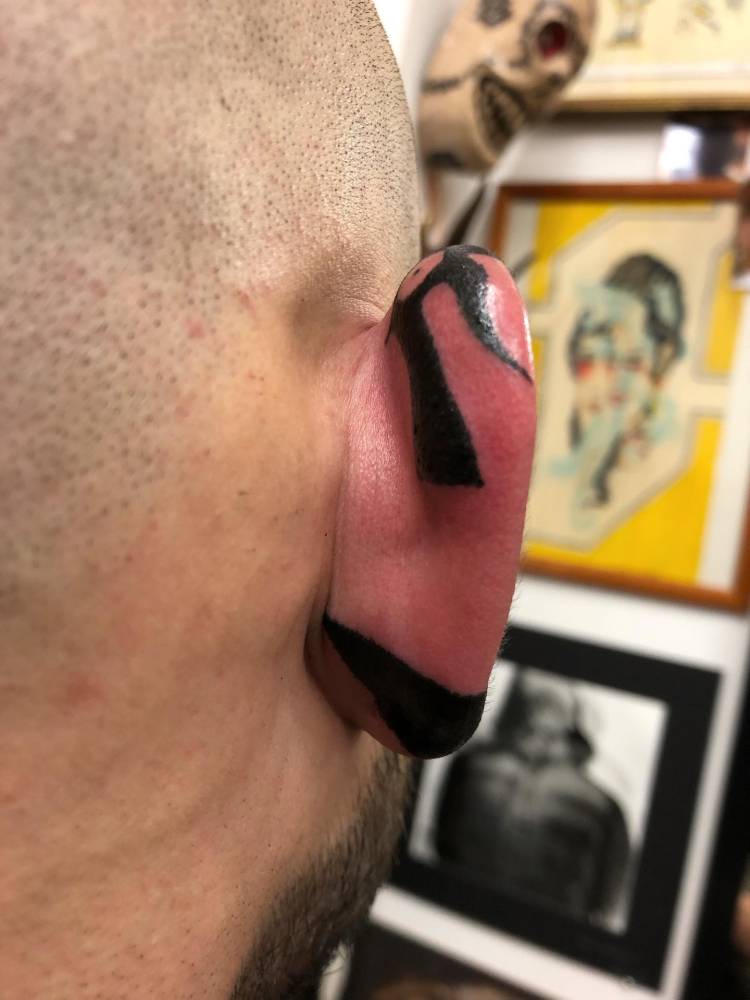 Hand poked tribal tattoo located on the ear.