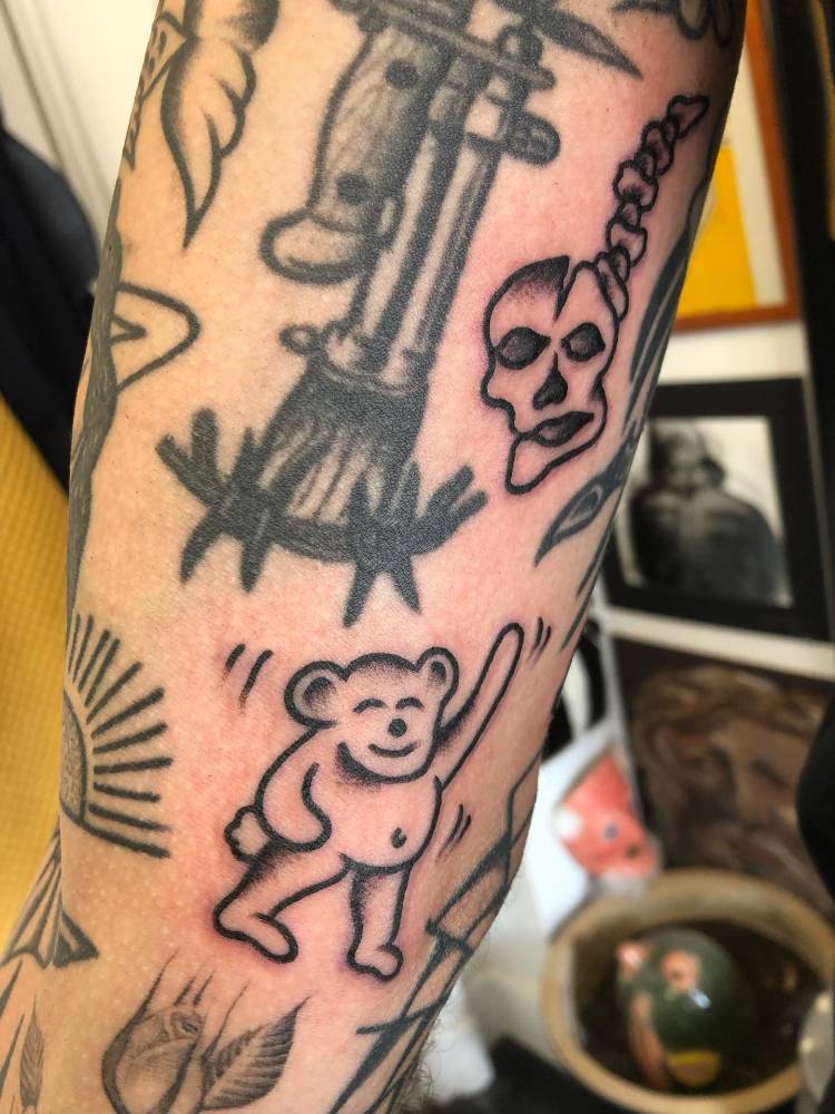 Hand poked Bear and skull tattoos located on the inner arm.